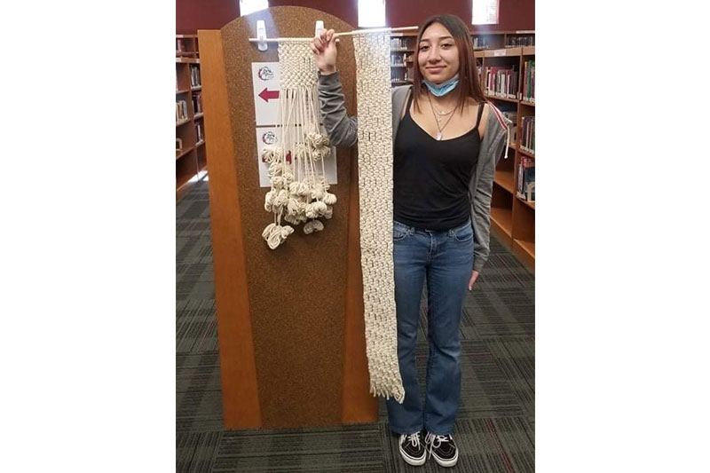 Student holding up her knitting project	slideshow